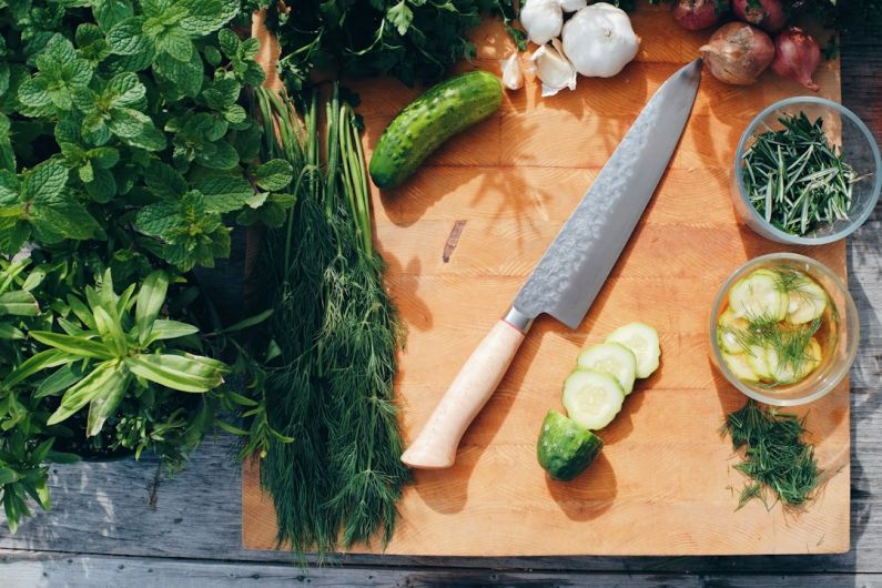 Fresh Herbs - sliced cucumber and green vegetable on brown wooden chopping board
