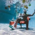 Pool Supplies - man sitting on chair underwater with floating bottles