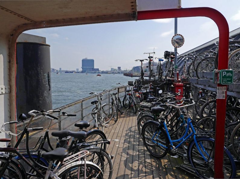 Bicycle Storage - bicycles parked beside railings near body of water during daytime